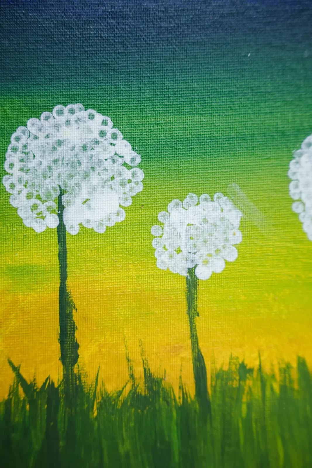 A tall painting of two white dandelion seed heads on thin stems against a green-to-yellow sky, with grass along the bottom.