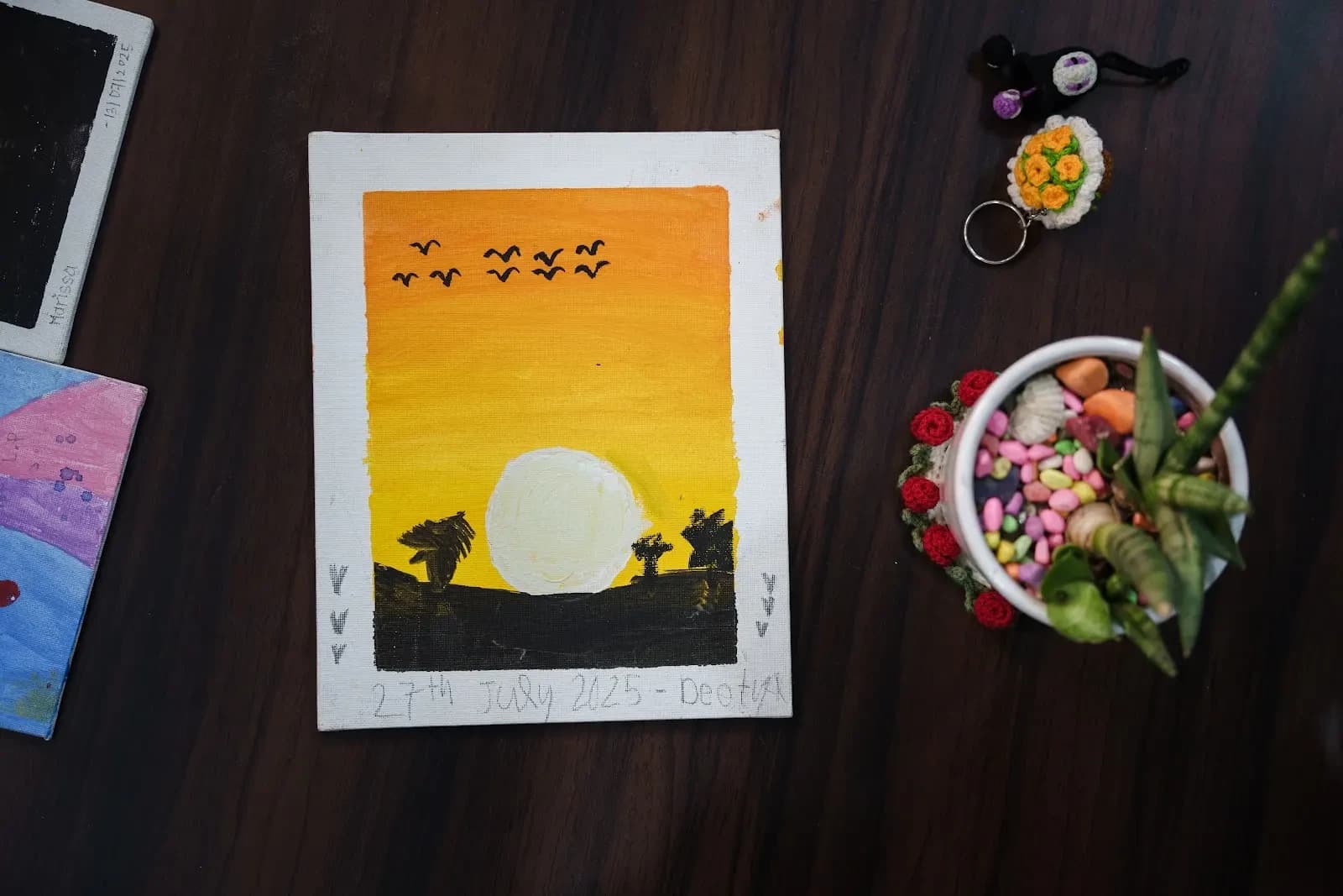 A painting of a large orange setting sun over a dark horizon, with small birds flying across a yellow sky.